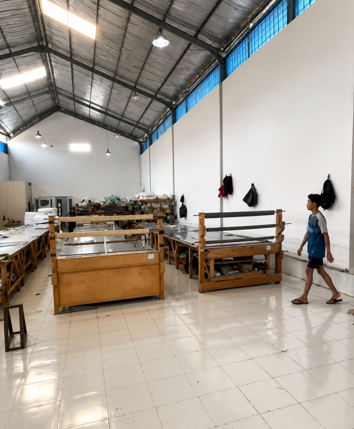 Pekerja konveksi tas di pabrik Indonesia tengah memproduksi tas dengan mesin dan bahan tekstil.